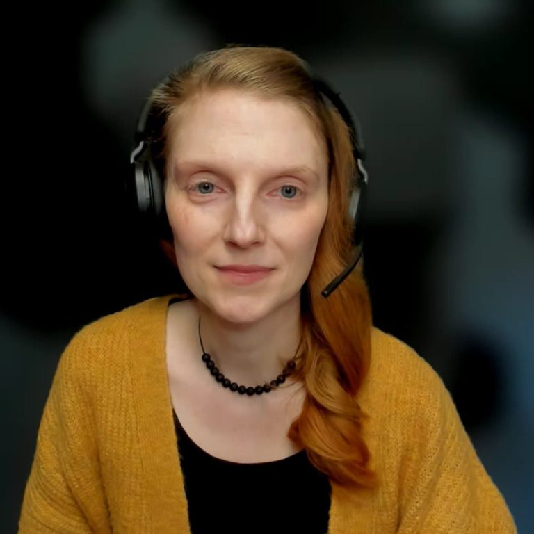 Online-Coaching Sitzung Person am Laptop, die an einem Videoanruf mit einer lächelnden Frau teilnimmt.